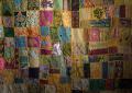 photo of a quilt with different patches of colors, floral shapes and sequins